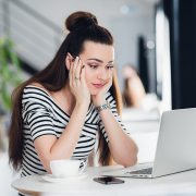 bored-young-woman-in-the-office-working-with-a-lap-PFP4N79